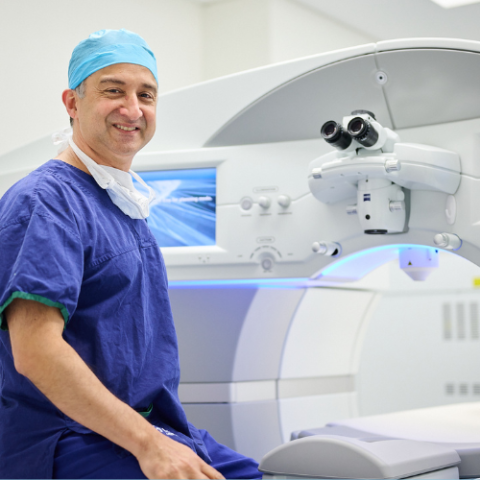 Dr Gagan Khannah sitting next to the laser eye machine